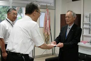 三条商工会議所からの100万円の寄付を新潟県央工高野球部を甲子園に送る会の梨本事務局長に手渡す阿部専務理事