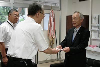 三条商工会議所からの100万円の寄付を新潟県央工高野球部を甲子園に送る会の梨本事務局長に手渡す阿部専務理事