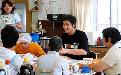 23日、「ねむの木工房」で開かれた収穫祭で利用者が調理したカレーライスなどを利用者と一緒に味わう新潟アルビレックBBの池田選手