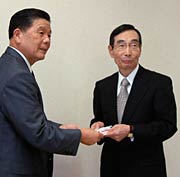  小林市長(左)に一輪車の目録を手渡す長谷川理事長(右)