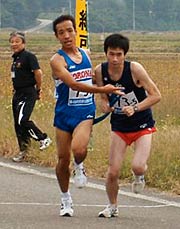 第4中継地点で最終走者にたすきをつなぐ総合第1位のコロナアスリートクラブ