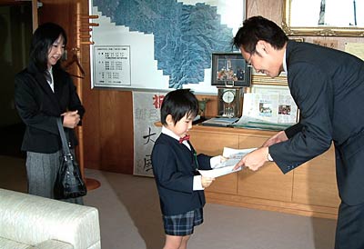 国定三条市長から第57回新潟県母と子のよい歯のコンクールで優秀賞の賞状を受け取る渋谷さん母子