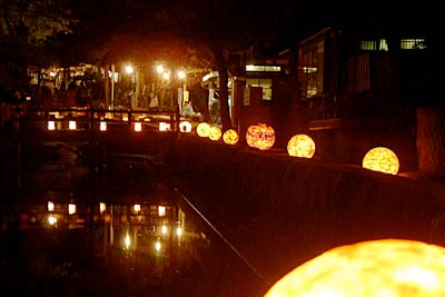 25日夜行われた加茂JCの「AKARIBA in 加茂山」で加茂山公園の池のふちに並ぶあかり