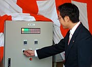 木質ペレットボイラーの着火式でスイッチを押して稼働させる国定市長