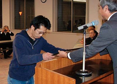 表彰式で最優秀大賞を受ける津村啓生さん