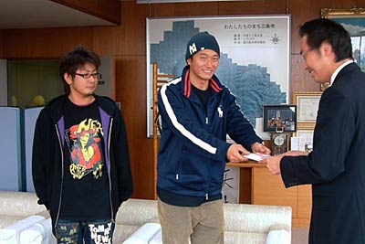 17日、国定三条市長に7万円を手渡す「チームぐっつらぁ」の石黒さんと小野さん