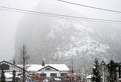 「しただブログ」に掲載された、かもしか病院から「いい湯らてい」越しにそびえ立つ八木ヶ鼻を白くした雪