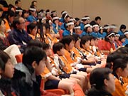 ほかの学校の演奏を真剣に聞く児童