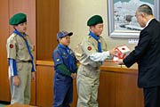 ボーイスカウト加茂第1団とガールスカウト新潟県第30団からそれぞれ善意が詰まった募金箱を小池市長に手渡す