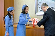 ボーイスカウト加茂第1団とガールスカウト新潟県第30団からそれぞれ善意が詰まった募金箱を小池市長に手渡す