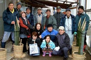 門松を作る西本成寺有志会の会員で記念写真