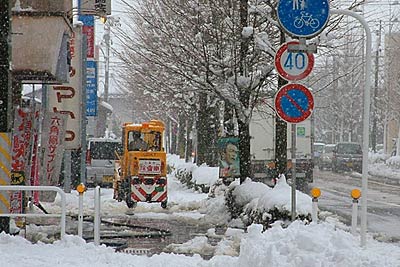 三条市役所前、降りしきる雪のなかで歩道除雪