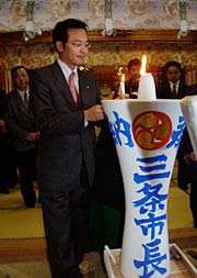 皮切りにろうそくに点火する国定市長
