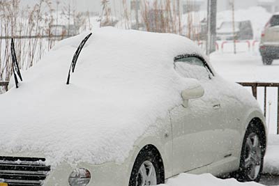雪が車をすっぽり覆う