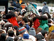 参拝者でいっぱいの境内をもみくちゃになって鐘楼堂へ向かう鬼たち