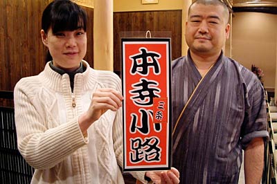 店頭に下げる目印の「千社札」ディスプレーと本寺小路元気プロジェクト船山会長(右)