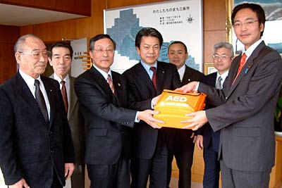三条市へ寄付するAEDを国定三条市長に手渡す三条、三条中央ライオンズ会員
