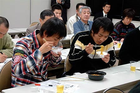 セブン-イレブン・ジャパン25日販売開始するレンジ麺「三条名物 カレーラーメン」の勉強会で試食する三条市と燕市のセブン-イレブン約30店のオーナー