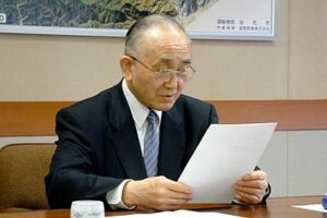 「県央広域市町村圏協議会において多数決は認められないことについて（通知）」を読み上げる小池加茂市長