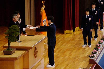 一人ひとり登壇して八幡校長から卒業処暑を受け取る卒業生