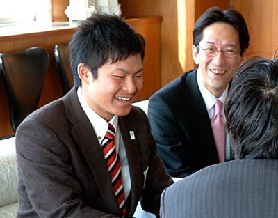 国定市長と歓談する渡辺さんといすゞ製作所の関川常務