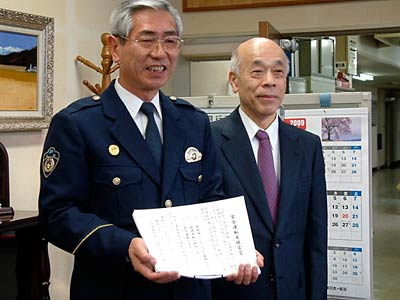 三条署で行われたシートベルト着用推進モデル事業所の宣言式で、宣言文を手に小船井三条署署長とコロナの内田社長