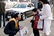 しゃがんで新1年生に交通安全を呼びかける国定市長