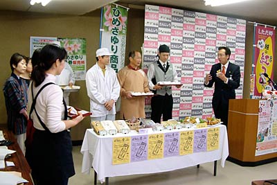 15日行われた国定三条市長定例会見で下田地区オリジナルのサツマイモのコロッケ「越の紅コロ」をPRするプロジェクトメンバー