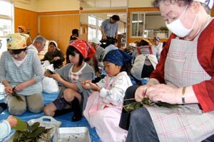 四日町いきいきセンター利用者の60歳以上と小学生が一緒に笹団子作り