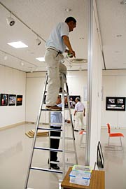 脚立も使って展示作業に励む会員
