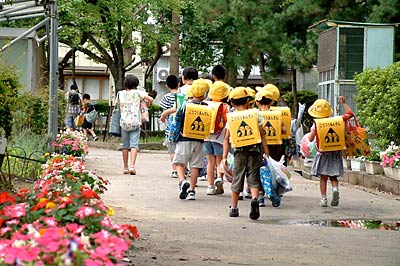 終業式が終わって玄関を出て足取りもはずむ児童