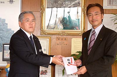 国定三条市長(右)に三条市への街路灯50基の寄付の目録を手渡す東北電力新潟県央営業所の武田所長(左)
