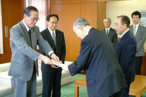 小池市長に車いす8台の目録を手渡す加茂信用金庫の梁取理事長ら
