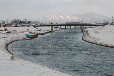 元日、三条市・常盤橋上流側の五十嵐川左岸から常盤橋、その向こうに弥彦山