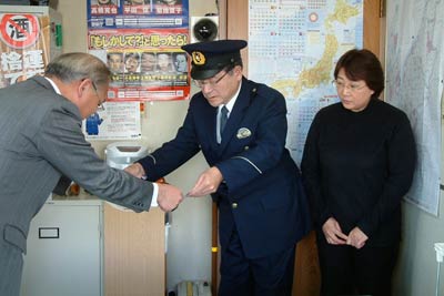 小池駐在所で笠原地域部長から表彰状の伝達を受ける阿部巡査部長、妻の美代子さん