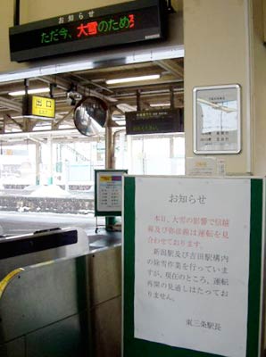改札口前の張り紙や電光掲示板で、雪のための運行見合わせを案内するJR東三条駅