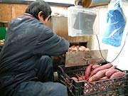軽トラの荷台でサツマイモを焼く熊倉さん