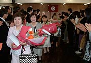 花束を胸に退場する退職者