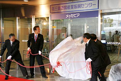 紅白のひもを引いて除幕