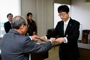 燕市長選に無投票当選して加藤選管委員長から当選証書を受ける鈴木氏