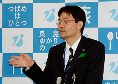 初登庁後、青と白のバックパネルの前で初めての記者会見を行う鈴木市長