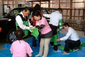 三条タクシーが初めて障害者疑似体験会を開き、ドライバーが疑似体験キットで高齢者の身体感覚を実感