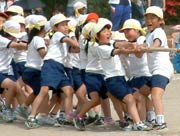 顔を真っ赤にして綱を引く児童