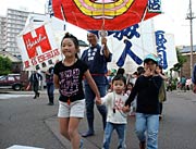 おとなも子ども一緒に凧を持ってパレード