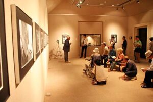 捧武写真展の作品解説会で写真と向き合う捧さんの言葉に約30人が耳を傾ける