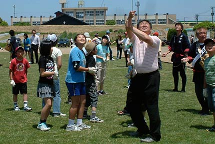 三条凧合戦会場で凧の糸を引く只見町の目黒町長と子どもたち