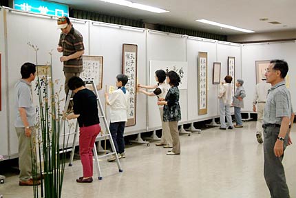 25日から27日まで三条市中央公民館で開かれている三條蘭亭会第23回書道展の展示作業