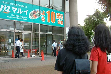 閉館し正面玄関の閉鎖を見守る市民