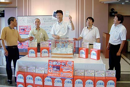 19日行われた燕市商店連合会の「夢がかなって得するセール」の抽選会、当たりくじを引く鈴木市長