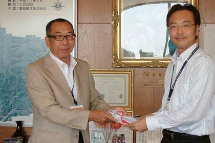国定市長にチャリティーからの10万円を手渡す新潟アルビレックス・ベースボール・クラブの藤橋代表取締役(左)